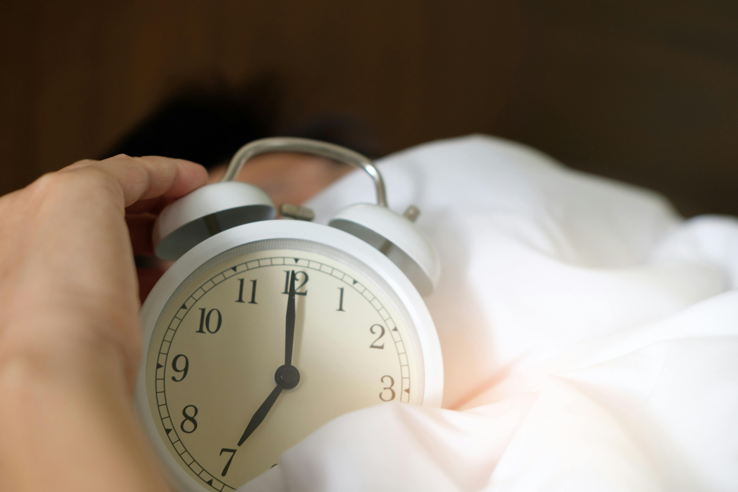 Person reaching for alarm clock